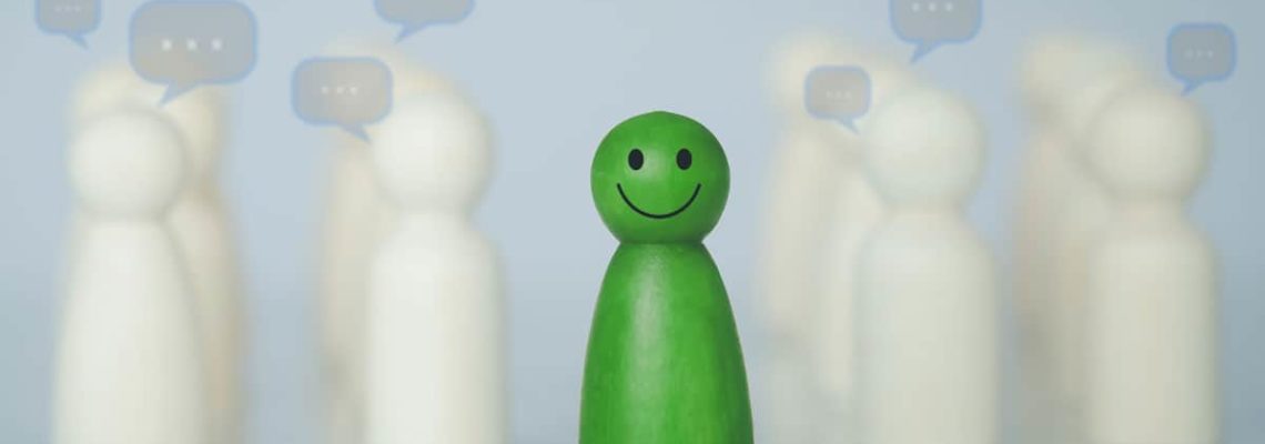 featured image of blogpost Career Tips for Introverts: The Right Job Green wood figure with happy face standing out from the crowd of different people. Individuality, Introvert, Not care when someone is talking, Unique human shape, Leadership, Human resource.