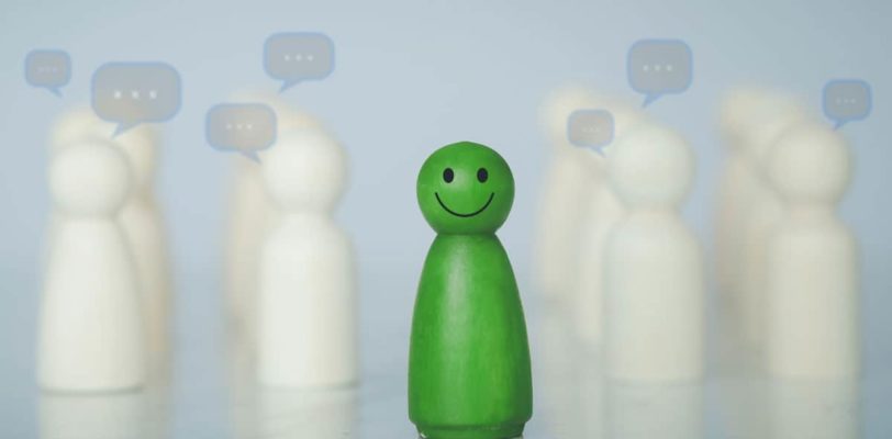 featured image of blogpost Career Tips for Introverts: The Right Job Green wood figure with happy face standing out from the crowd of different people. Individuality, Introvert, Not care when someone is talking, Unique human shape, Leadership, Human resource.