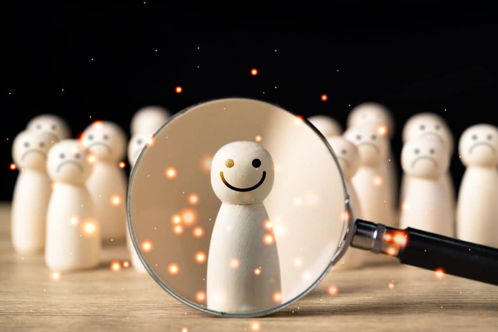 featured image of blogpost "Career Tips for Introverts:: Hot to be Successful", part two of a three-part series. Shows a white wooden figure highlighted by a lens and sparkly lights