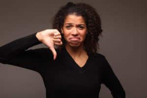 Featured image of article "Is Your Diversity Program Failing?" showing a beautiful afro lady with thumb down on dark background