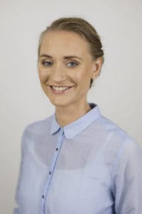 Portrait photo of role model Katja Dörlemann on grey background smiling into camera