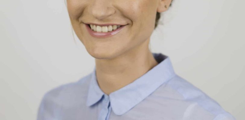 Portrait photo of role model Katja Dörlemann on grey background smiling into camera