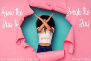 Featured image for article "Know the Bias to Break the Bias" for the International Women's Day 2022 with the motto #BreakTheBias, showing a woman breaking through a pink paper background with her arms in an X pose