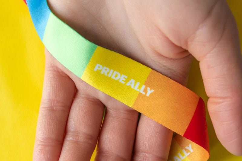 LGBT symbol - hand with rainbow ribbon and pride ally, the concept of support of the LGBT community