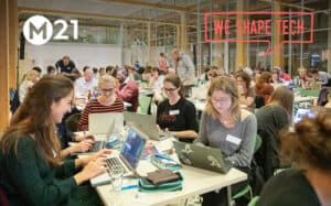 Participants at group tables complete their first steps of the code