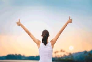 Featured image of the third part of the blogpost series about Self-Leadership called "Tips to Avoid Overwhelm" showing a victorious person standing in front of a sunset with the back to the reader